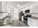 Well-lit kitchen featuring stainless steel appliances, white cabinets, and light gray flooring at 2225 Grace Church Rd, Salisbury, NC 28147