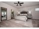 Serene bedroom with a statement bed frame, plush carpeting, and large windows for natural light at 242 Hamptons Cove Rd, Troutman, NC 28166