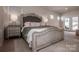 Elegant primary bedroom features plush carpeting, a large decorative bed, and ample natural light at 242 Hamptons Cove Rd, Troutman, NC 28166