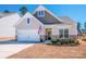Lovely home exterior with a two-car garage, manicured lawn, and decorative shrubbery at 242 Hamptons Cove Rd, Troutman, NC 28166