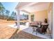 Enjoy outdoor living on this covered patio featuring stylish furniture and a peaceful backyard view at 242 Hamptons Cove Rd, Troutman, NC 28166