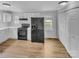 Well-lit kitchen with white cabinets, black appliances, and modern flooring at 279 Timberland Loop, Mooresville, NC 28115