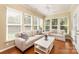 Relaxing sunroom with hardwood floors, white sofas, and large windows offering serene views at 3052 Santee Ct, Indian Land, SC 29707