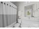 Bright bathroom featuring a large mirror, white vanity, and shower with striped curtain at 3655 Vallette Ct, Charlotte, NC 28203