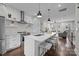 Open-concept kitchen with island seating, stainless steel appliances, and modern white cabinetry, open to the living room at 3655 Vallette Ct, Charlotte, NC 28203