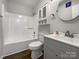 Clean, white bathroom featuring a shower-tub combo, modern vanity, and storage cabinet at 426 W Ballard St, Cherryville, NC 28021