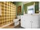 Bathroom showcasing a white vanity, toilet, mirror and green plaid shower curtain at 4633 River Bluff Ct, Charlotte, NC 28214