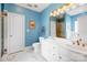 Bright blue bathroom featuring double sinks, white cabinets, and a separate shower and toilet room at 4633 River Bluff Ct, Charlotte, NC 28214