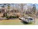 Scenic view of boat dock on the lake and wooded surroundings, with lake house in the background at 4633 River Bluff Ct, Charlotte, NC 28214