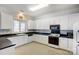 Well-lit kitchen with white cabinets, black countertops, and modern appliances at 4633 River Bluff Ct, Charlotte, NC 28214