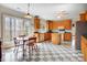 Bright kitchen with wood cabinets, a center island, checkered floors, and a breakfast table by the window at 4633 River Bluff Ct, Charlotte, NC 28214