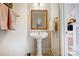 Bright powder room with a pedestal sink, gold fixtures, and stylish decor at 4633 River Bluff Ct, Charlotte, NC 28214