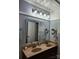 Bathroom with double sinks, granite countertop, and a large mirror with modern lighting at 5434 Beckhaven Ln, Charlotte, NC 28216