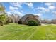 Large backyard with green grass surrounding a brick home at 6000 Embassy Ct, Wesley Chapel, NC 28110