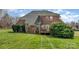 Spacious backyard with green lawn and a brick house in the background at 6000 Embassy Ct, Wesley Chapel, NC 28110