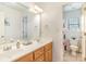 Bright bathroom featuring a double vanity and an adjacent powder room at 6000 Embassy Ct, Wesley Chapel, NC 28110