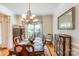 Elegant dining room with chandelier, wood table, and china cabinet at 6000 Embassy Ct, Wesley Chapel, NC 28110