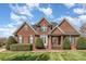 Charming brick home featuring a well-manicured lawn and mature landscaping at 6000 Embassy Ct, Wesley Chapel, NC 28110