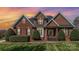 Charming brick home featuring a well-manicured lawn and mature landscaping at 6000 Embassy Ct, Wesley Chapel, NC 28110