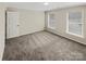 Neutral bedroom featuring carpet, two windows, and a closet door at 670 Sherwood Pl, Mooresville, NC 28115