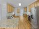 Well-equipped kitchen with granite counters, stainless steel appliances, and wood cabinets at 670 Sherwood Pl, Mooresville, NC 28115
