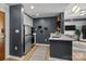 Compact kitchen featuring stainless steel appliances, white cabinets, dark accent wall and breakfast bar at 715 N Church St # 503, Charlotte, NC 28202