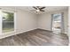 A sunlit bedroom with wood-look flooring, a ceiling fan and two windows with blinds at 7212 Hackberry Ln, Charlotte, NC 28226