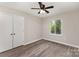 A well-lit bedroom features wood-look flooring, a ceiling fan and a closet at 7212 Hackberry Ln, Charlotte, NC 28226