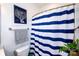 Cozy bathroom with a striped shower curtain, decorative accents, and fresh greenery at 769 Seigle Point Dr, Charlotte, NC 28204