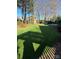 Landscaped backyard featuring a pergola, artificial lawn, and mature trees at 8011 Greencastle Dr, Charlotte, NC 28210