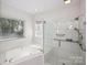 Bright bathroom featuring a soaking tub, glass-enclosed shower, and double windows at 8011 Greencastle Dr, Charlotte, NC 28210
