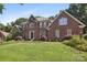 Stately brick home with well-maintained landscaping, mature trees, and a welcoming front yard at 8011 Greencastle Dr, Charlotte, NC 28210