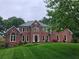 Stately two-story brick home with manicured lawn and mature trees at 8011 Greencastle Dr, Charlotte, NC 28210