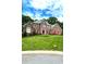 Charming red brick two-story home with a well-manicured green lawn and lush trees at 8011 Greencastle Dr, Charlotte, NC 28210