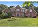 Imposing two-story brick home with a manicured lawn and mature landscaping at 8011 Greencastle Dr, Charlotte, NC 28210