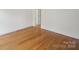 Bright living room featuring polished wood floors, white base trim, and natural light at 8011 Greencastle Dr, Charlotte, NC 28210