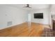 Living room with hardwood floors and an adjacent brick fireplace and doorway at 8011 Greencastle Dr, Charlotte, NC 28210