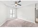 This bedroom has neutral walls, carpet, and trim and a large window providing natural light at 8155 Cedar Glen Dr, Charlotte, NC 28212