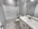 Clean bathroom featuring a tub-shower combo, white tile, and a white vanity with modern fixtures at 8212 Merryvale Ln, Charlotte, NC 28214