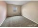 Cozy bedroom with neutral walls, carpet flooring, and a window providing natural light at 8212 Merryvale Ln, Charlotte, NC 28214