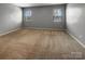 Spacious bedroom featuring neutral walls, carpet flooring, and two windows for natural light at 8212 Merryvale Ln, Charlotte, NC 28214