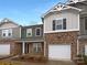 Charming townhome with a brick facade, attached garage, and manicured landscaping, offering great curb appeal at 8212 Merryvale Ln, Charlotte, NC 28214