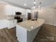 Modern kitchen featuring white cabinetry, stainless steel appliances, and a large center island with quartz countertop at 8212 Merryvale Ln, Charlotte, NC 28214