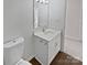Compact bathroom featuring a toilet, modern vanity, and ample lighting at 8715 Green Ivy Ln, Charlotte, NC 28217