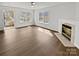 Bright living room featuring modern fireplace, hardwood floors, and ample natural light from large windows at 8715 Green Ivy Ln, Charlotte, NC 28217