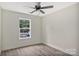 This bedroom features a ceiling fan, a window overlooking the yard, and neutral walls and flooring at 914 Saluda St, Rock Hill, SC 29730