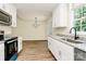 Bright kitchen featuring white cabinetry, granite countertops, modern appliances, and wood-look flooring at 914 Saluda St, Rock Hill, SC 29730