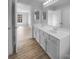 Bathroom with double vanity sink, white cabinets, and wood floor at 9144 Cameron Wood Dr, Charlotte, NC 28210