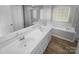 Bright bathroom featuring double sinks, soaking tub, and separate shower at 9144 Cameron Wood Dr, Charlotte, NC 28210