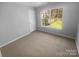 Bedroom featuring a neutral carpet, a large window and white trim at 9144 Cameron Wood Dr, Charlotte, NC 28210